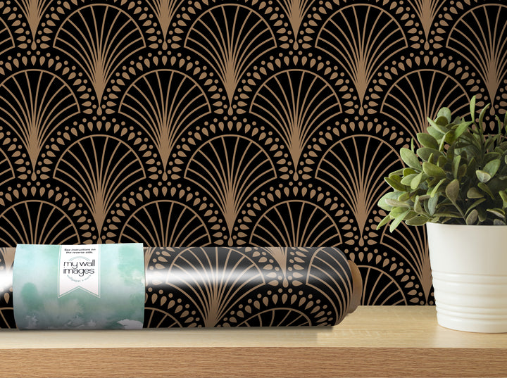 a decorative wall with a repeating pattern of black and gold fan-like designs, and a potted plant placed on a shelf next to the wall.
