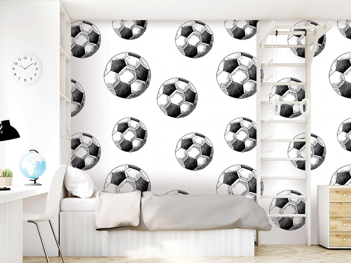 a bedroom with a white bed, a desk, a clock, and a bookshelf. The walls are decorated with a repeating pattern of soccer balls, creating a soccer-themed atmosphere.