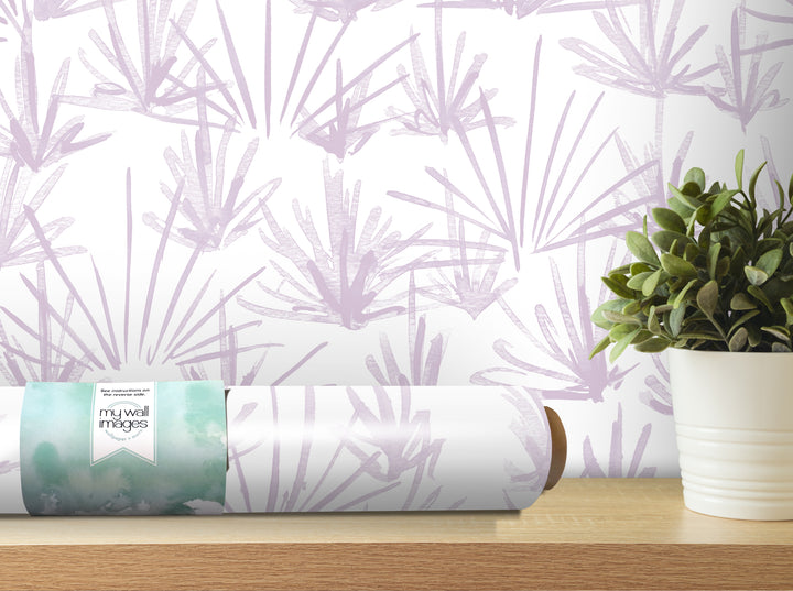 a roll of wallpaper with a purple and white abstract pattern, placed on a wooden shelf next to a potted plant.