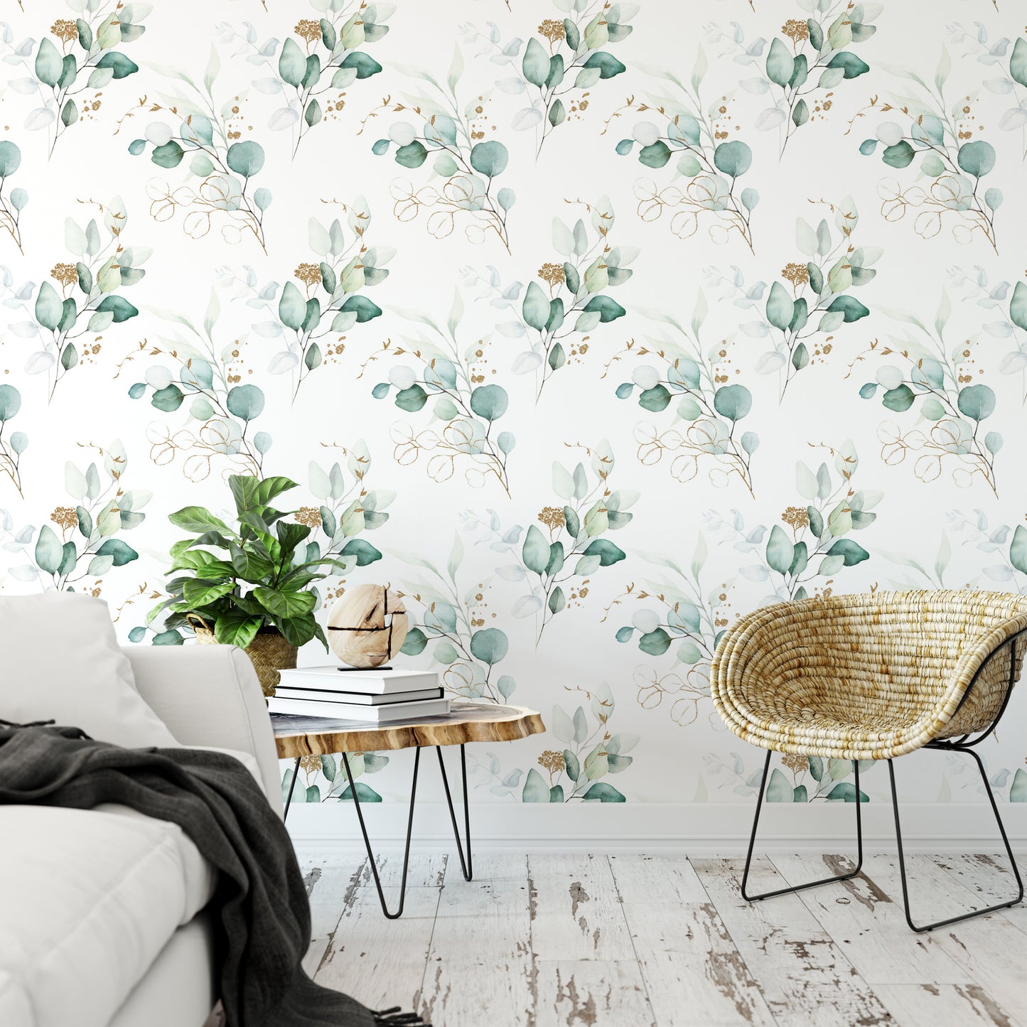 a living room with a white sofa, a woven chair, and a wooden coffee table. The walls are adorned with a floral wallpaper pattern in shades of green and gold. The room has a cozy and inviting atmosphere, with a potted plant and a stack of books adding to the homely ambiance.
