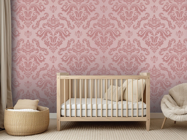 a nursery room with a wooden crib, a beige chair, and a woven basket. The room has a pink and white damask pattern on the walls, creating a warm and cozy atmosphere.