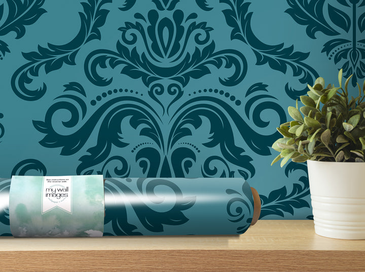 a roll of wallpaper with a blue floral pattern, a potted plant, and a wooden shelf against a blue and green patterned wall.