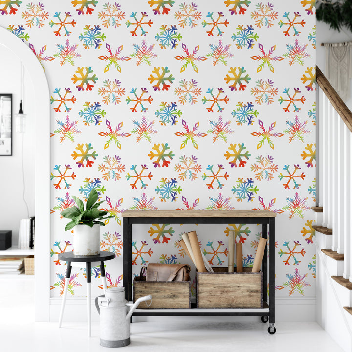 a wall with a vibrant, colorful snowflake pattern, creating a festive and cheerful atmosphere. In the foreground, there is a small table with a potted plant and a wooden crate, adding a touch of warmth and natural elements to the scene.