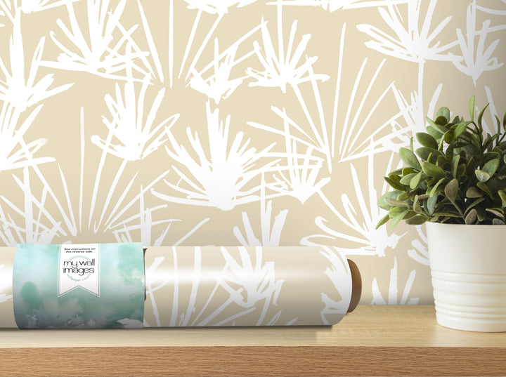 a roll of wallpaper with a white floral pattern, placed on a wooden shelf next to a potted plant.