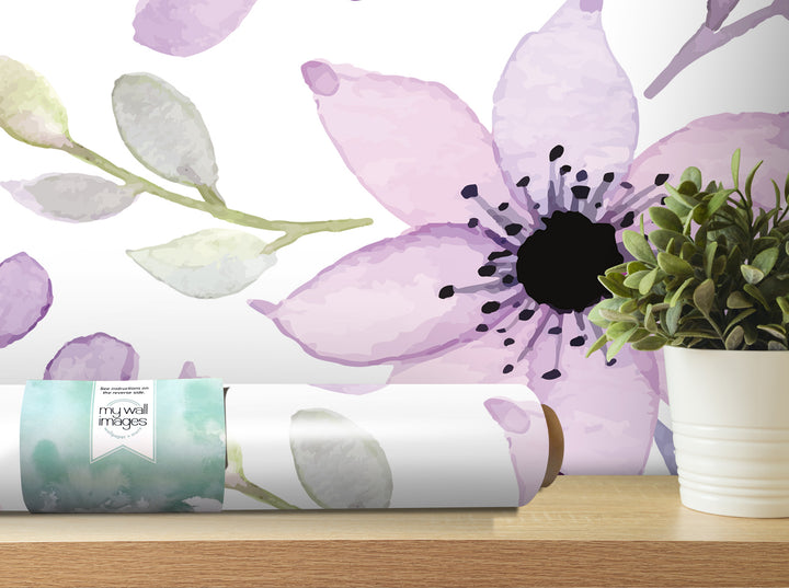 a large purple flower with a black center, displayed on a shelf next to a potted plant.