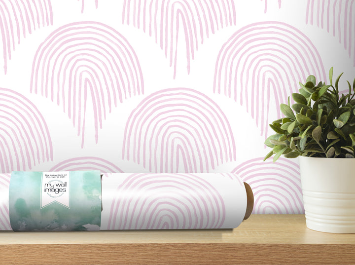 a wallpapered wall with a repeating pattern of pink and white arches, and a potted plant is placed on a wooden shelf next to the wallpapered wall.