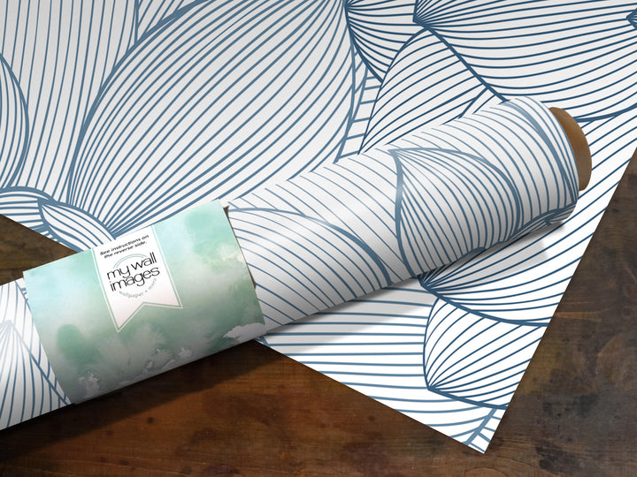 A roll of wallpaper with a blue and white striped pattern is shown on a wooden surface.