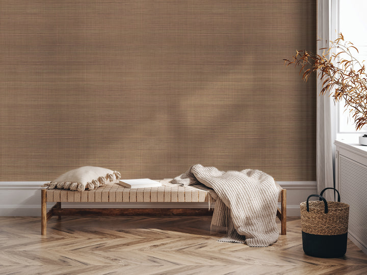 a cozy and inviting living space with a wooden bench, a woven basket, and a plant. The bench is adorned with a white pillow and a blanket, creating a comfortable seating area. The woven basket is placed next to the bench, and a plant is situated nearby, adding a touch of nature to the room. The overall scene conveys a sense of warmth and relaxation.