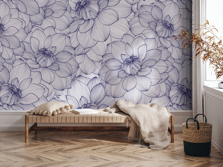 a living room with a large floral wallpaper covering the wall behind a wooden bench. The bench is positioned in front of the wall, and there is a woven basket nearby. The room has a hardwood floor, and a potted plant is visible on the right side of the image.