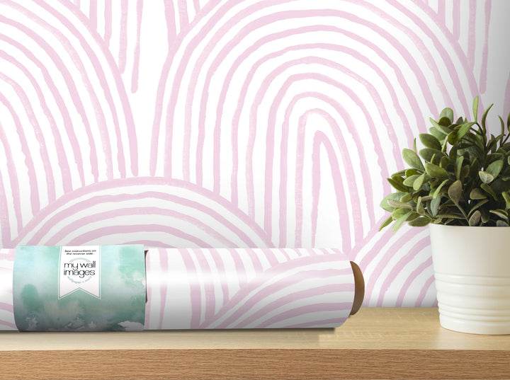 a pink and white striped wallpaper on a wall, with a potted plant and a roll of wallpaper on a shelf next to it.