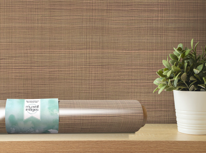 a wooden shelf with a potted plant and a roll of wallpaper on it.