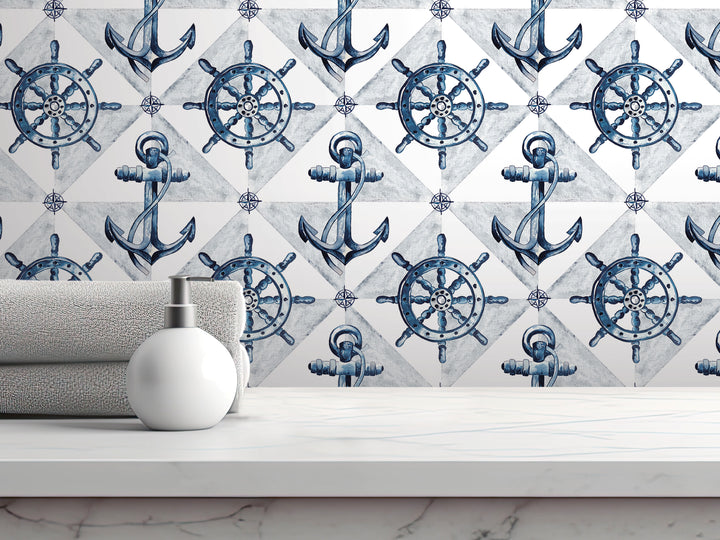 a white countertop with a white soap dispenser and a gray towel, set against a backdrop of a repeating pattern of blue and white nautical-themed designs, including anchors, ship wheels, and steering wheels.