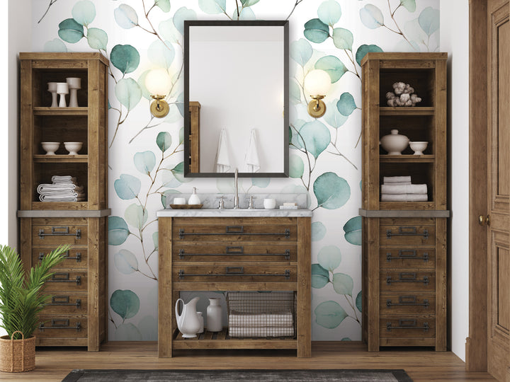 a bathroom with a wooden vanity, a mirror, and shelves. The walls are decorated with a watercolor-style wallpaper featuring green leaves.