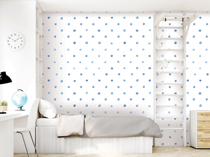 A modern bedroom with a white bed, a dresser, and a ladder against the wall. The walls are covered in blue polka dots, and there is a clock on the wall.