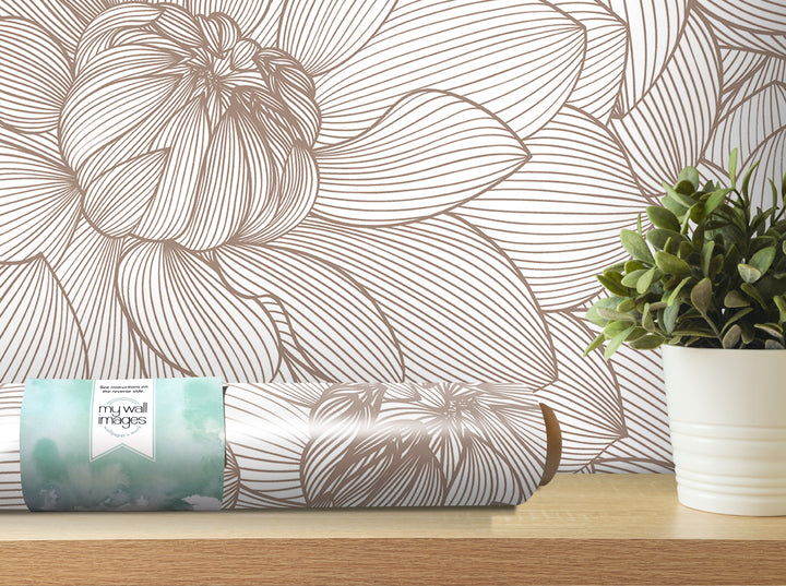 a wallpapered wall with a large floral pattern, a potted plant, and a roll of wallpaper on a shelf.
