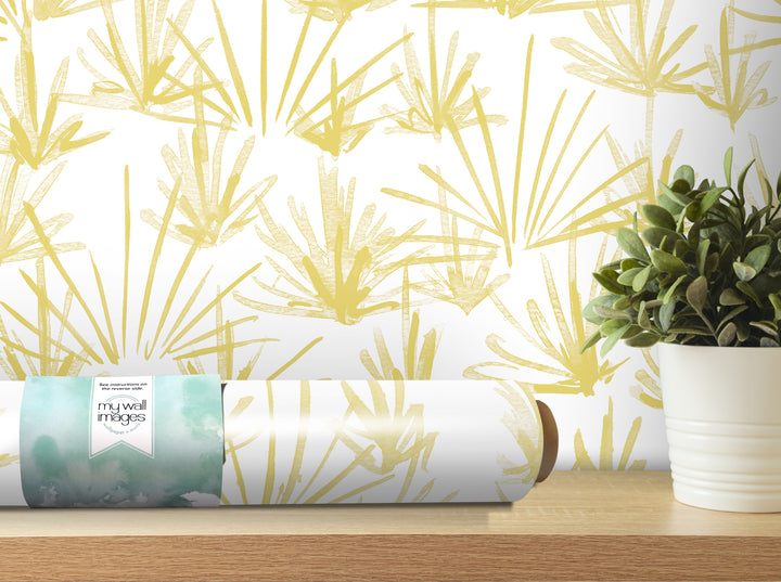 a wallpapered wall with a yellow and green leaf pattern, a potted plant, and a roll of wallpaper on a shelf.