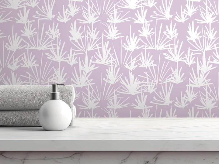 a white pump soap bottle on a white countertop, with a folded towel and a purple wall with a white floral pattern in the background.