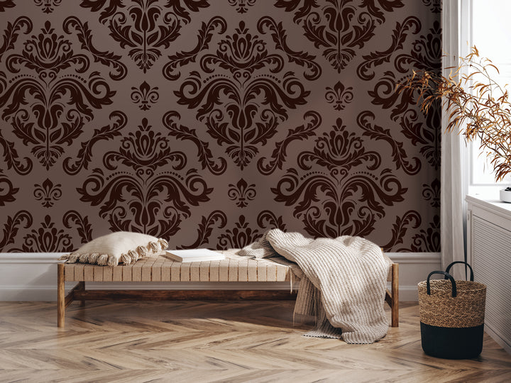 a cozy living room with a brown and white damask wallpaper, a wooden bench with a blanket and pillows, and a woven basket on the floor.