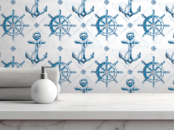 a white countertop with a white soap dispenser and a gray towel, set against a wall with a repeating pattern of blue and white anchors and ship wheels.
