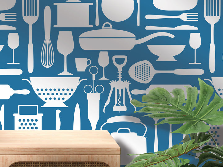 a wall with a repeating pattern of various kitchen utensils and appliances, including a variety of knives, spoons, bowls, and other cooking tools, all depicted in white against a blue background.