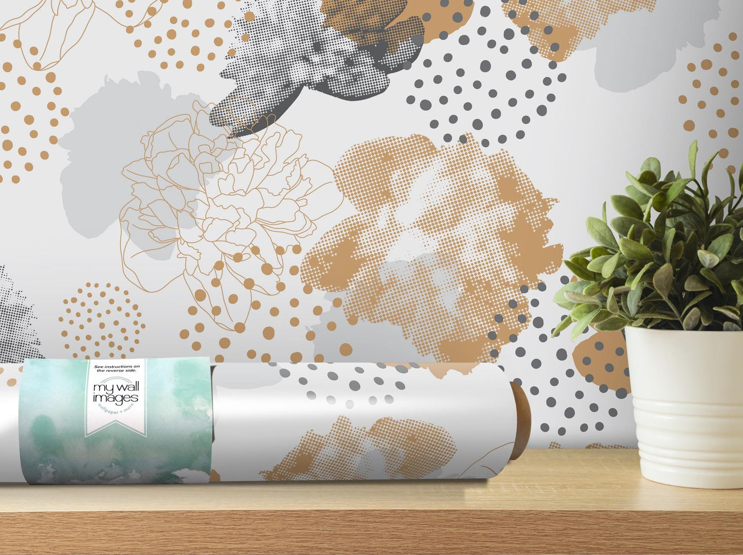 a vase with a plant on a table next to a roll of wrapping paper