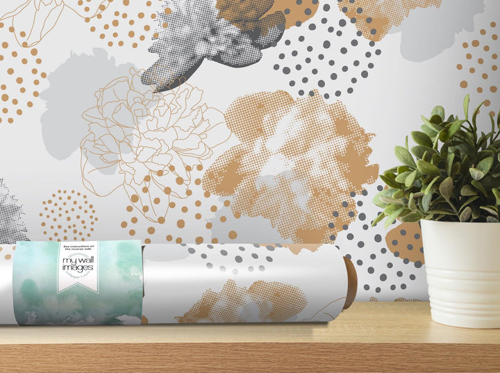 a vase with a plant on a table next to a roll of wrapping paper