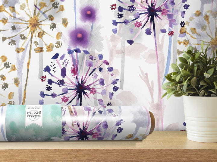 a vase with a plant next to a roll of wrapping paper