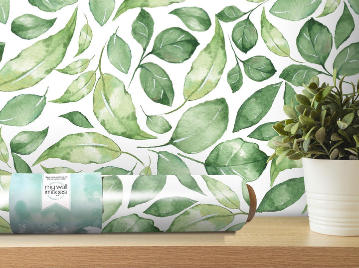 a painting of green leaves on a white wall