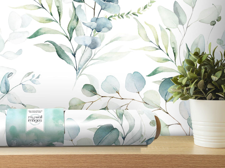 a vase with a plant next to a wall paper