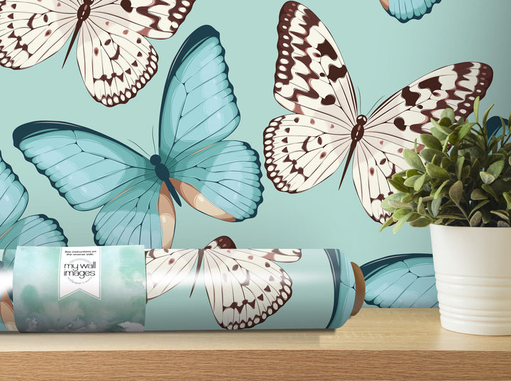 a vase with a plant in it next to a blue wall with butterflies on it