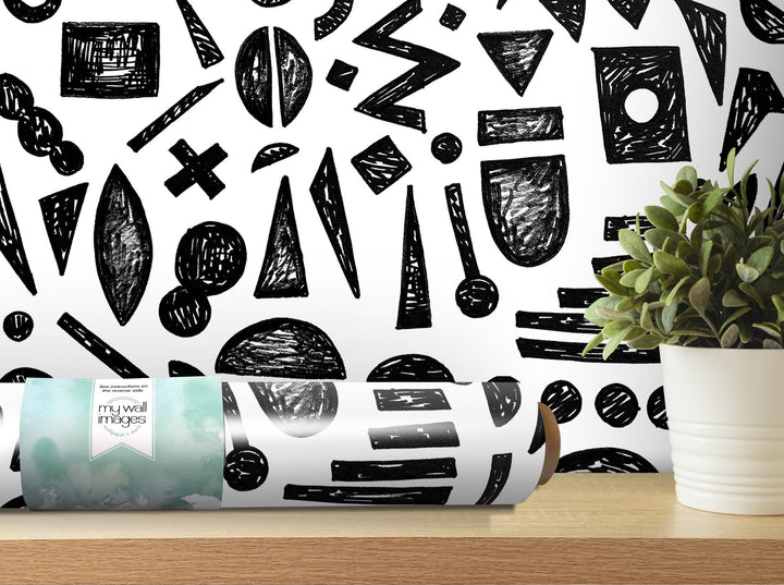 a white vase filled with a plant next to a black and white wall