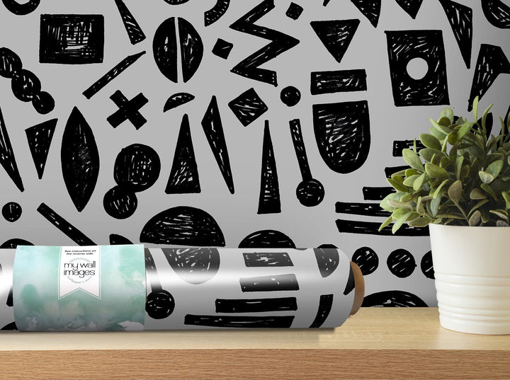 a black and white pattern on a wall next to a potted plant