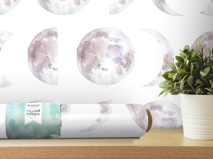 a vase with a plant on a table next to a roll of paper