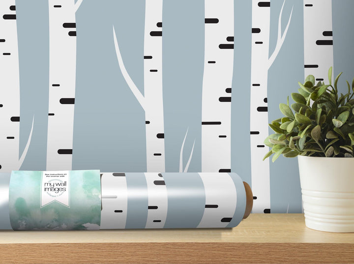 a plant is sitting on a table next to a roll of wrapping paper