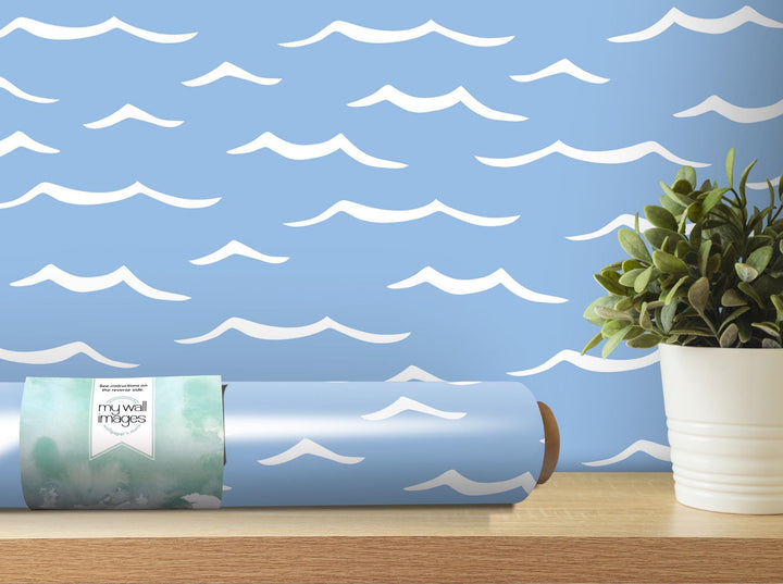 a vase with a plant in it next to a roll of wrapping paper