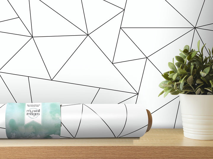 a white vase with a green plant on a table