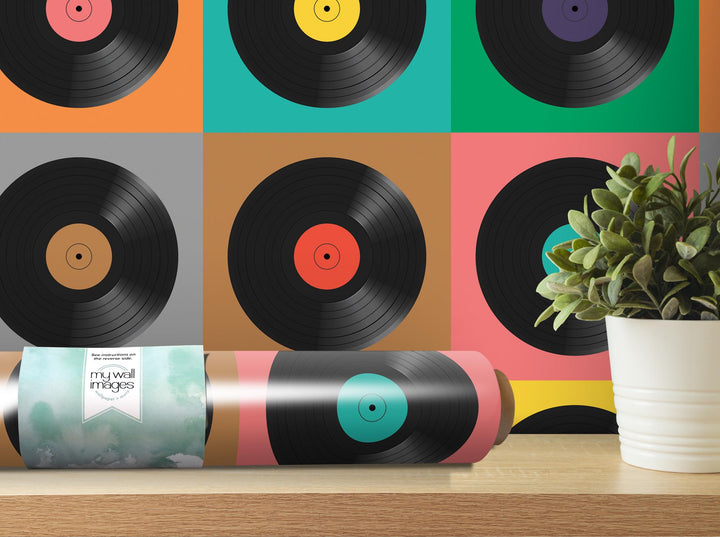 a vinyl record on a table next to a potted plant