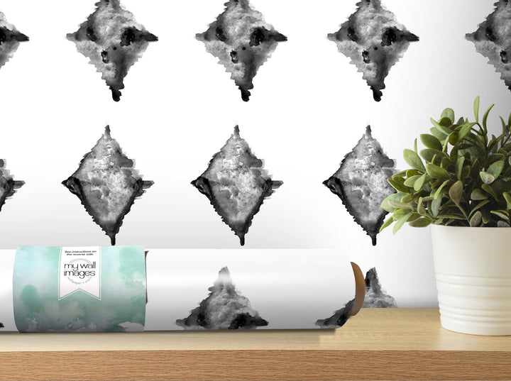 a white vase with a plant in it next to a wallpaper