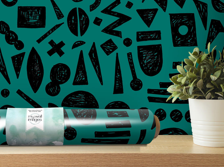 a plant is sitting on a table next to a roll of wrapping paper