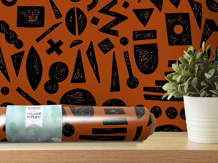 a plant is sitting on a table next to a roll of wrapping paper