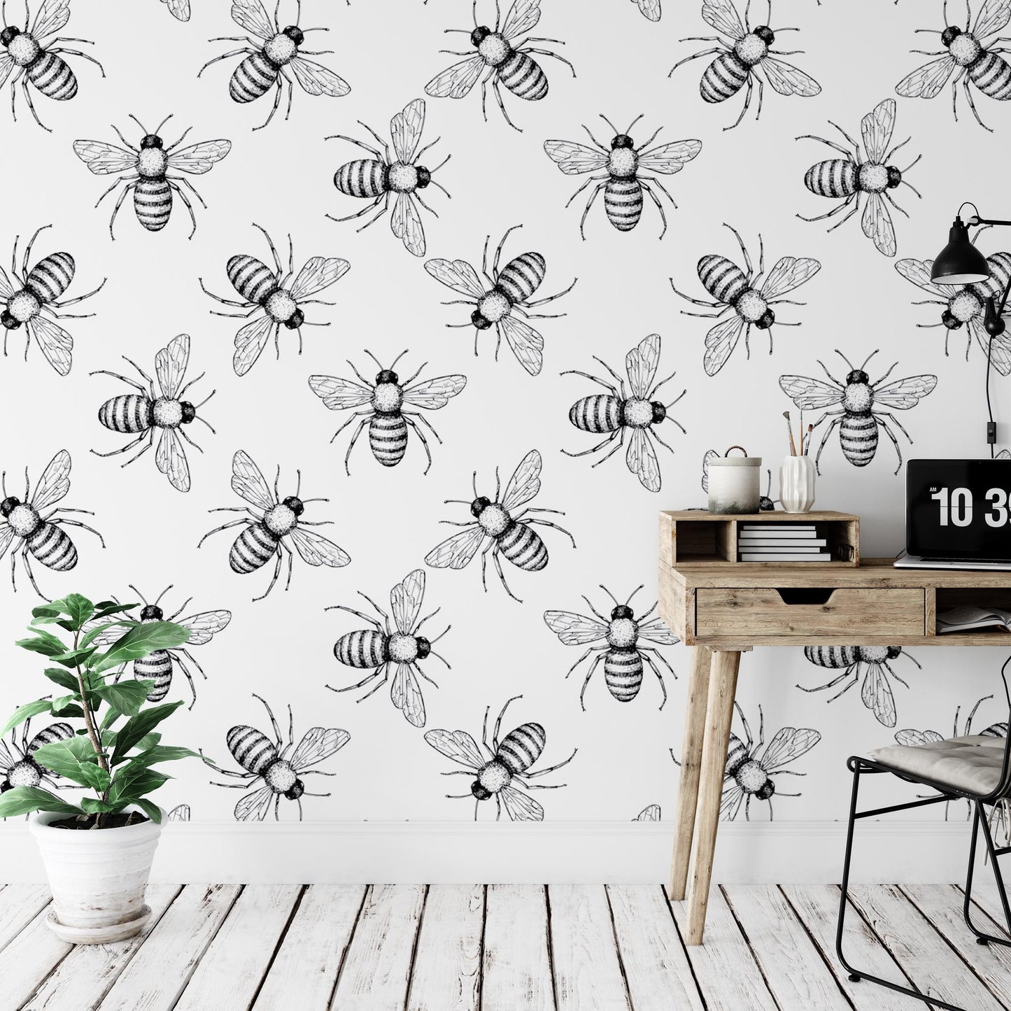 a desk with a potted plant and a wallpaper with bees on it