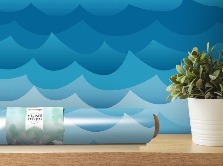 a vase with a plant in it next to a roll of wrapping paper