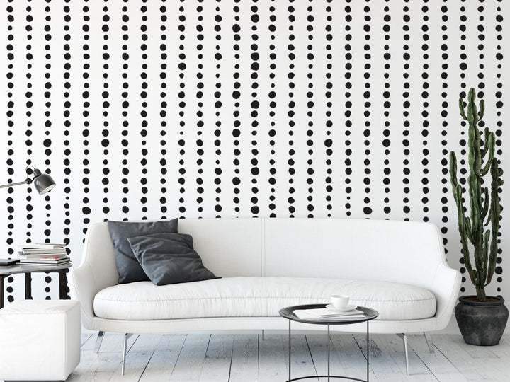 a white couch sitting next to a black and white wall