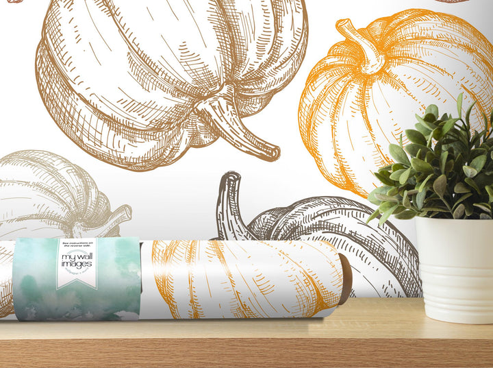 a painting of pumpkins on a wall next to a potted plant
