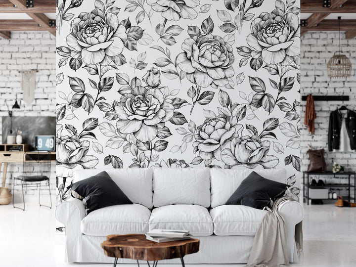 a white couch sitting in front of a wall covered in flowers