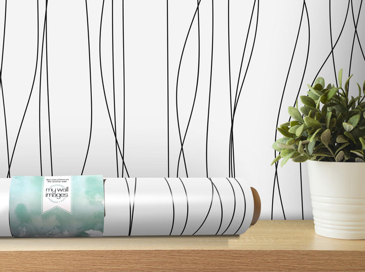 a plant sits on a table next to a roll of wrapping paper