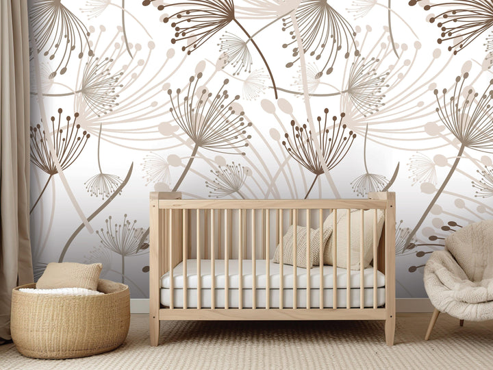a nursery room with a wooden crib, a woven basket, and a plush chair. The room has a neutral color scheme with a large wall mural featuring a repeating pattern of dandelions and other flowers.