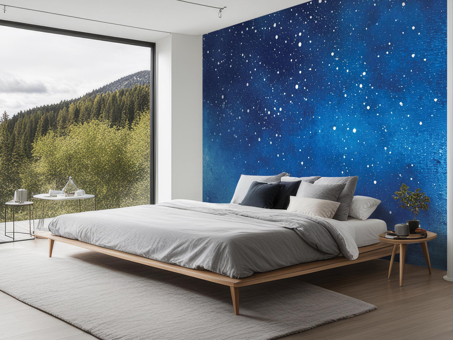 a modern bedroom with a large bed, a nightstand, and a window overlooking a forested area.