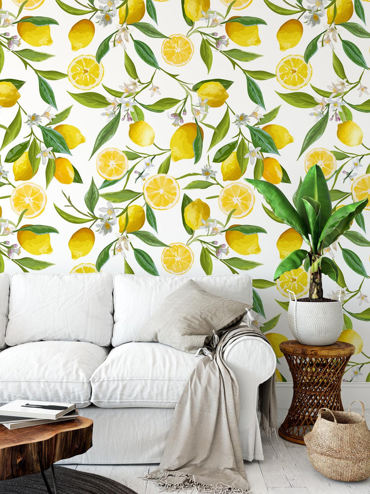 a white couch sitting in front of a wall covered in lemons