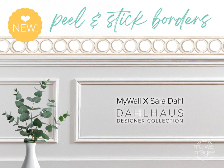 a white wall with a decorative border, a vase of green leaves, and text that reads "MyWall X Sara Dahl Dahlhaus Designer Collection".